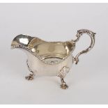 A George II style silver sauce boat, London 1905, with double scroll handle and gadrooned wavy rim,