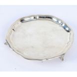 A silver card waiter, Sheffield 1921, with wavy rim, on three feet, faintly inscribed,