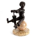 A bronze figure of a clown with umbrella, seated on an alabaster sphere on a flat circular base,