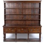 An oak dresser with shelves over, fitted three drawers, on turned legs with platform under,