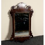 A small mahogany wall mirror with carved ear pieces,