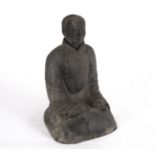 A black pottery figure of a seated Chinaman with nodding head, incised character marks,