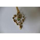 A 9ct gold seed pearl and emerald pendent on associated chain (5.2 g).
