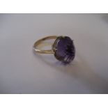 A yellow metal purple stone ring.
