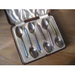 A cased set of silver enamel spoons.