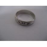 A 9 ct white gold wedding band with bright cut decoration, 3.4g all in.