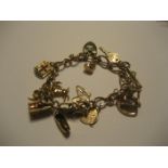 A 9ct gold charm bracelet with numerous gold charms, 28.2g (all in).