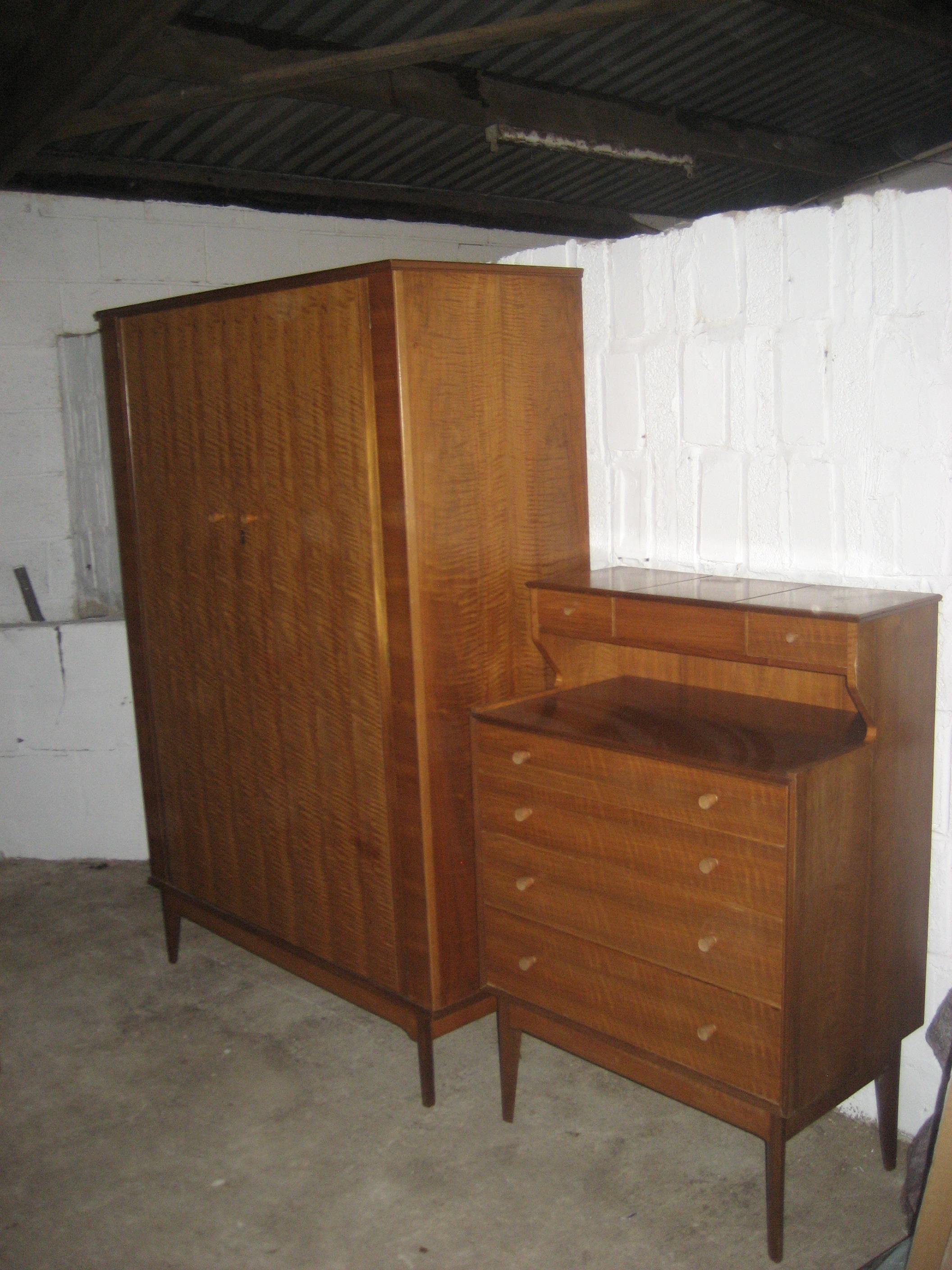 An Alfred Cox mid 20th bedroom suite comprising two bedroom chests, a wardrobe, a dressing table and