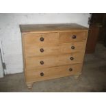 A late 19th / early 20th pine chest of drawers raised on bun feet.