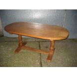 A Peter Heap oak dining table of oval from with large signature rabbit to one leg. Adzed top.