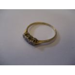 A three stone 18ct gold diamond ring, 2.2g.