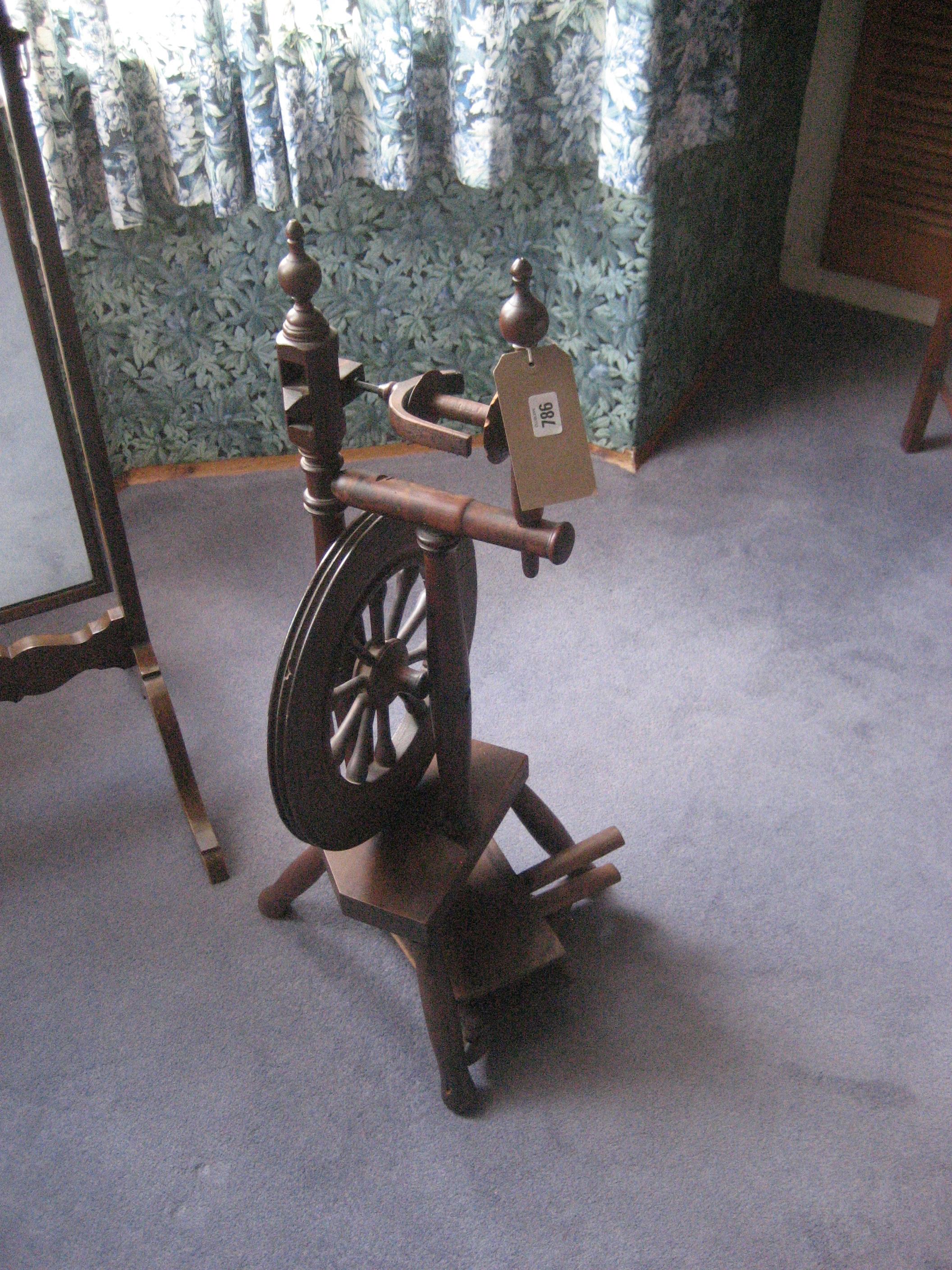 An early 20th century beech spinning wheel and a pair of wool pats.