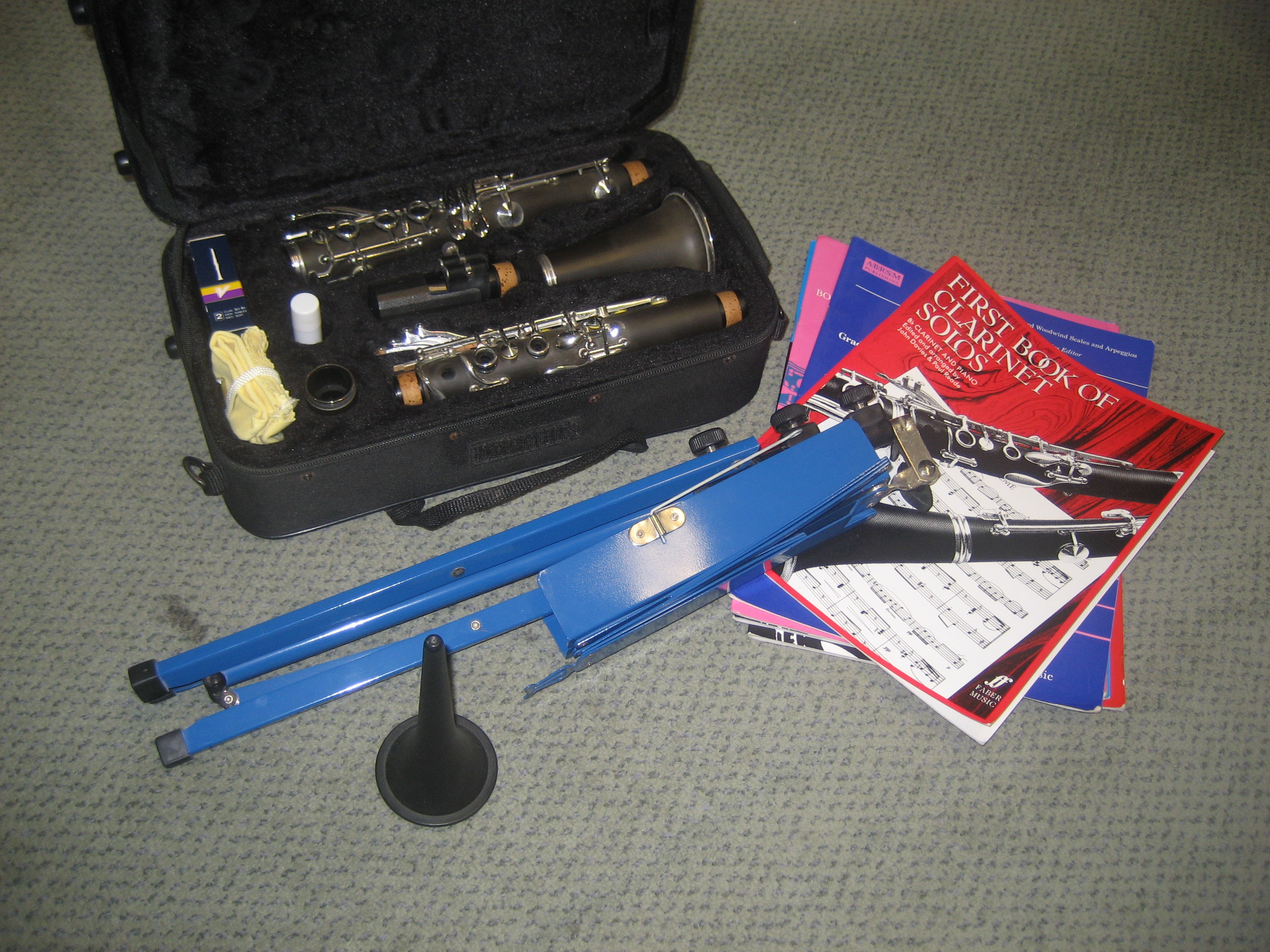 A CASED CLARINET WITH MUSIC STAND ETC.