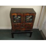 AN EARLY 20TH JAPANESE SPECIMEN CABINET ON STAND. TWO MOTHER OF PEARL INLAID DOORS OPEN TO REVEAL