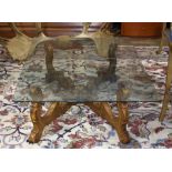 Hollywood Regency style cocktail table, having a glass rectangular top over the gilt composite "x"