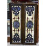 Pair of stained glass panels, each executed in multiple colors and having a wood molding, 30"h