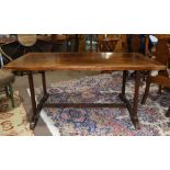 Continental primitive harvest table, having a rectangular plank top above the trestle base and