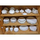 Three shelves of Wedgwood porcelain table service, in the "Doric" pattern, consisting of 8 dinner