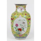 Chinese enameled porcelain vase, with floral reserves on a yellow ground with dense floral