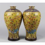 Pair of Chinese cloisonne enameled metal vases, of meiping form, featuring butterflies and flowering