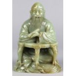 Chinese hardstone sculpture, of a scholar holding a scroll and seated at a desk with zoomorphic