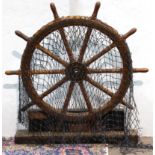 Brass and turned wood ship's wheel on stand with netting, 55"h x 54"w. Provenance: Property from the