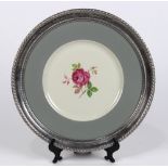 Sterling silver and porcelain charger, having a polychrome rose bloom reserve framed by a gray rim