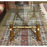 Hollywood Regency style low table, having a rectangular glass top, above the faux bamboo gilt