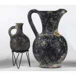 (lot of 2) Etruscan style blackware vessel group, consisting of a ewer and small jug, the jug with a