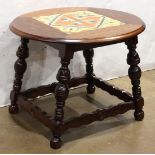 Arts and Crafts style tile top table, having a circular top and rising on turned legs, 18"h x 24"w x