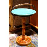 Mid century modern style stand, having a turquoise Bauer ceramic platter resting on a turned