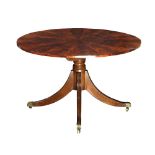 Regency flame mahogany center table, having a circular tilt top, above a baluster form standard, and