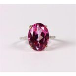 Pink colored topaz, diamond and platinum ring Featuring (1) oval-cut pink colored topaz, accented by