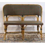 French bistro rattan bench, having a shaped back in green and burgundy caning, above the matching