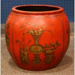 Red lacquered ceramic fish bowl, decorated with reserves of various scholar's items in gilt, 15"h