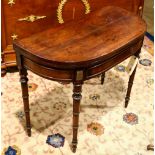 Federal mahogany demi-lune games table, having a flip top and rising on turned legs, 29"h x 36"w x