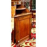 Provincial corner cabinet, the triangular form having a shelved top over a paneled door case,