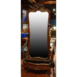 Rococo Revival pier mirror, having a shaped and bevelled looking glass centering the rocaille carved