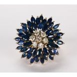 Diamond, sapphire and 14k yellow gold flower ring Centering (7) full-cut diamonds, weighing a