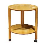 Mid Century tiered occasional table, having a circular top and rising on contoured legs conjoined by