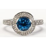 Blue topaz, diamond and 18k white gold ring Centering (1) round-cut blue topaz, weighing