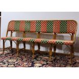 French bistro rattan bench, having a shaped back in green, red and golden caning, above the matching