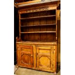 Primitive pine hutch, the pierced cornice above three fitted shelves and two lower cabinet doors,