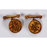 Pair of 18k yellow gold cufflinks Featuring (2) round discs, featuring Health and Wealth Chinese
