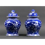 Pair of Chinese underglaze blue porcelain lidded jars, featuring prunus on a cracked-ice ground