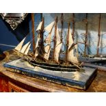 Model of a fully rigged sailing ship, hand-painted and rising on a custom naturalistic base, 27"w
