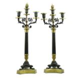 Pair of French Empire style bronze and brass candelabra, each having three lights, above a reeded