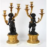 Continental Louis XVI style candelabra, after Clodion, each executed in gilt and patinated bronze,