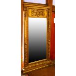 Large gilt pier mirror, having a relief decorated frieze above the rectangular mirror, and rising on
