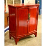 Chinese red lacquered cabinet, fronted by a pair of hinged double doors, concealing shelves and a